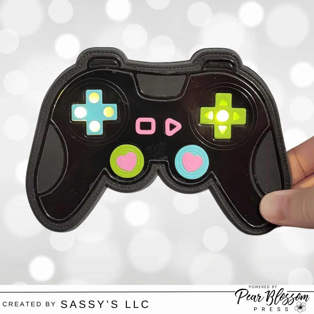Hi Friends, Sara Lihz here from @sassysllc I have a fun double-interactive card for you today. This game controller has light-up buttons and spinning joysticks. Check out the full tutorial over on the Pear Blossom Press YouTube Channel. 

Happy Crafting! 

@scrappyboy_losangeles #cardmaking #interactivecards #lightupcard #pearblossompress
